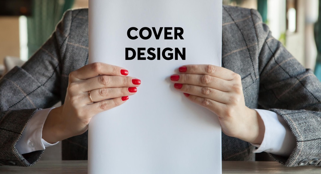 Bild Person h�lt ein Heft mit dem Titel „Cover Design“ aufrecht vor sich